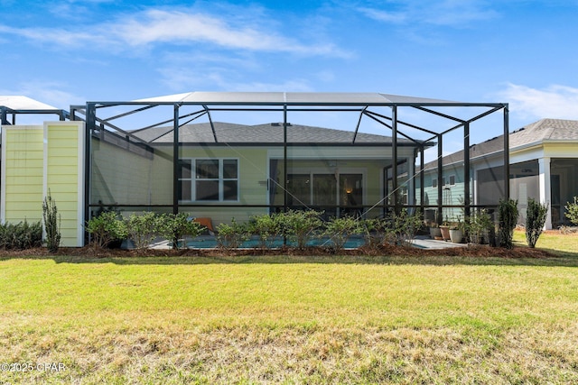 rear view of property featuring a lanai and a lawn