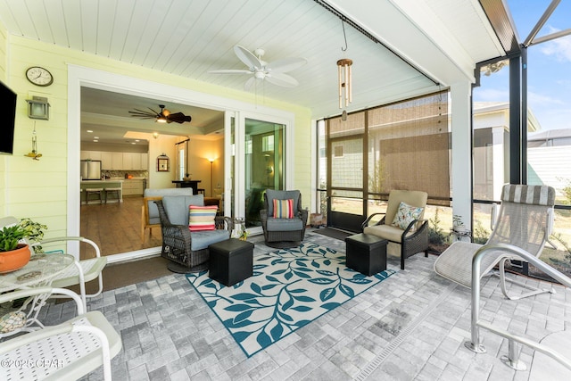 sunroom / solarium featuring a ceiling fan