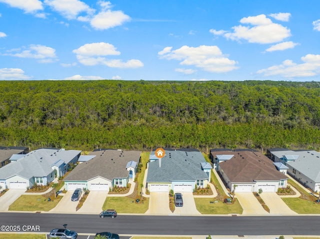 birds eye view of property featuring a forest view and a residential view