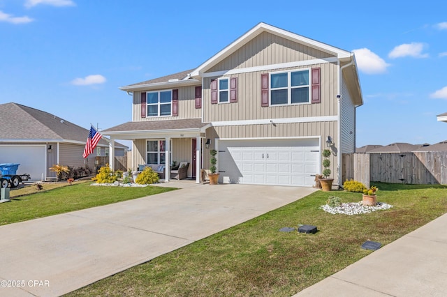 traditional home featuring a front yard, fence, an attached garage, covered porch, and concrete driveway