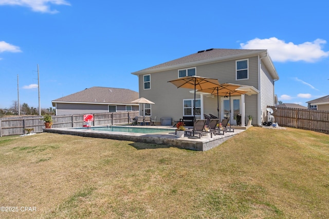 rear view of house featuring a yard, a fenced backyard, a fenced in pool, and a patio