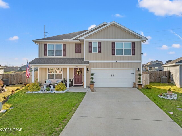 traditional home featuring a porch, concrete driveway, a front yard, and fence