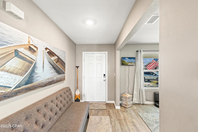 entrance foyer featuring wood finished floors, visible vents, and baseboards