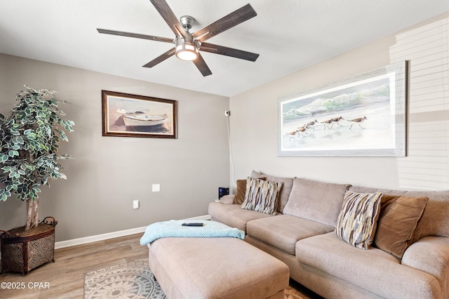 living room with baseboards, light wood-type flooring, and ceiling fan