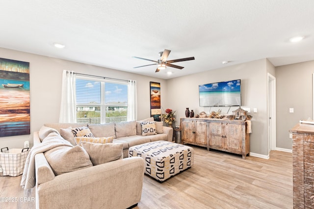 living area featuring baseboards, light wood-style flooring, recessed lighting, ceiling fan, and a textured ceiling