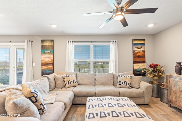 living area featuring recessed lighting, a textured ceiling, a ceiling fan, and light wood-style floors