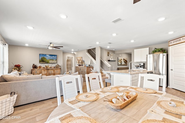 dining space with recessed lighting, visible vents, light wood-style flooring, and stairs