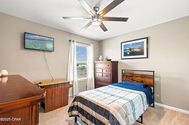 carpeted bedroom featuring baseboards and ceiling fan