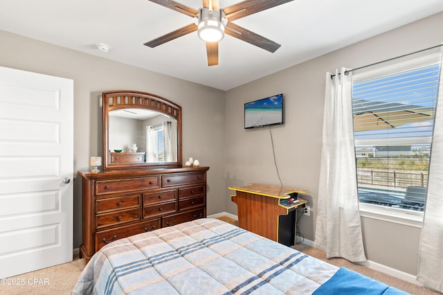 carpeted bedroom featuring multiple windows, baseboards, and ceiling fan