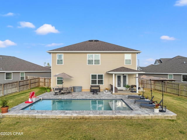 back of property with french doors, a patio, a yard, and a fenced backyard