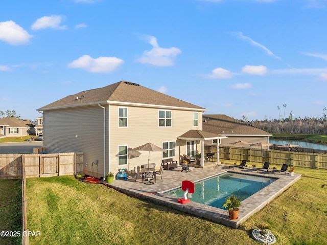 rear view of property with a water view, a fenced backyard, a yard, a fenced in pool, and a patio area