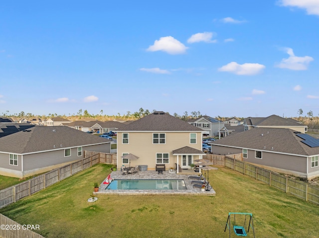 rear view of house featuring a fenced in pool, a residential view, a yard, a fenced backyard, and a patio area