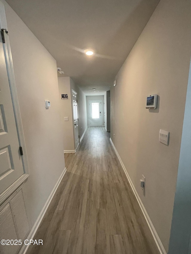 hall featuring baseboards and wood finished floors