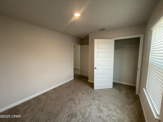 unfurnished bedroom with carpet floors, a closet, visible vents, and baseboards