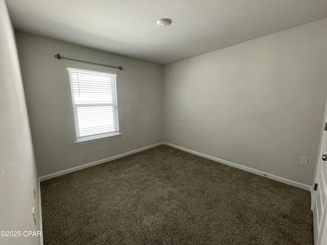 carpeted empty room featuring baseboards and a textured ceiling