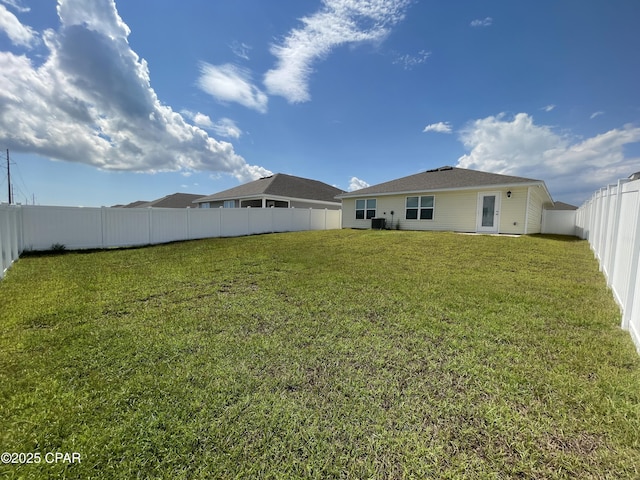 back of property featuring a fenced backyard and a yard