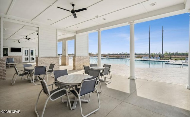 view of patio / terrace featuring ceiling fan, a community pool, and outdoor dining space