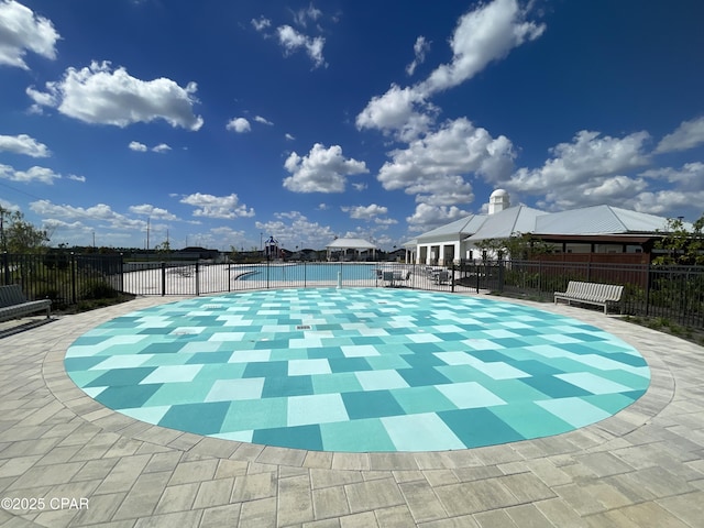 community pool with fence and a patio