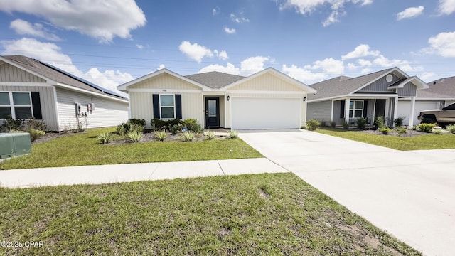 view of front facade with driveway, a shingled roof, an attached garage, and a front yard