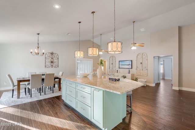 kitchen featuring a center island, pendant lighting, dark wood-style flooring, a breakfast bar area, and high vaulted ceiling