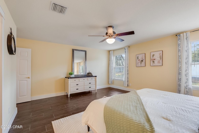 bedroom featuring a ceiling fan, visible vents, dark wood finished floors, and baseboards