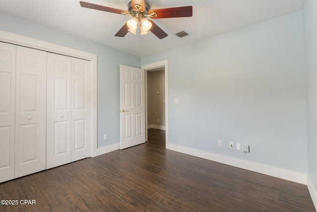 unfurnished bedroom featuring dark wood finished floors, a closet, visible vents, a ceiling fan, and baseboards