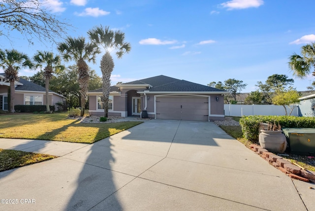 view of front of property with stucco siding, an attached garage, fence, driveway, and a front lawn