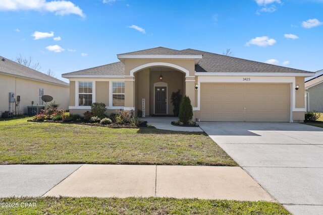 ranch-style house featuring a front lawn, concrete driveway, an attached garage, and stucco siding