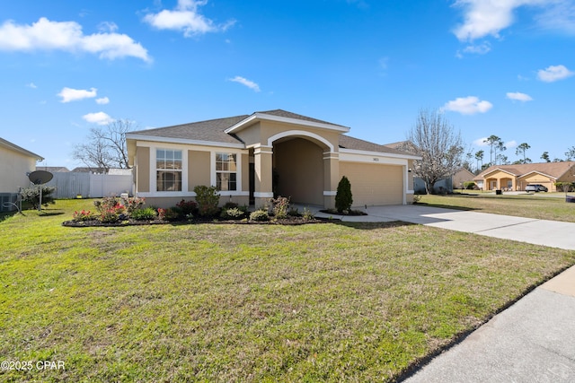 view of front of home with stucco siding, fence, concrete driveway, a front yard, and a garage