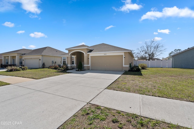 view of front facade with a front lawn, an attached garage, driveway, and stucco siding
