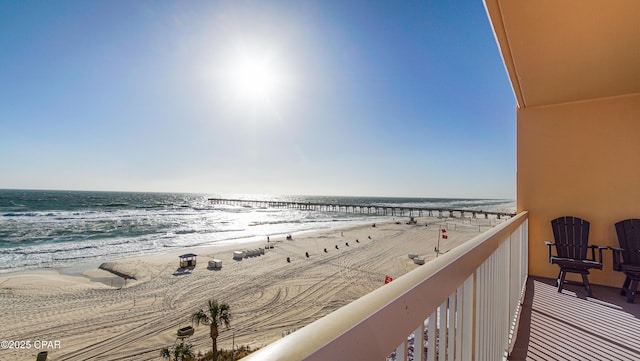 balcony featuring a beach view and a water view