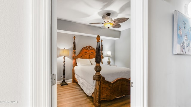 bedroom featuring light wood-style flooring, baseboards, and ceiling fan