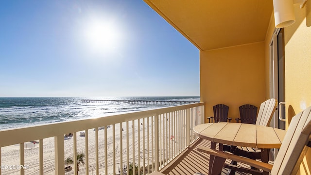 balcony featuring a beach view and a water view