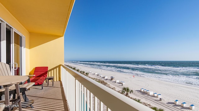 balcony featuring a view of the beach and a water view