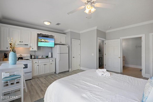 bedroom featuring a sink, freestanding refrigerator, light wood-style floors, crown molding, and baseboards