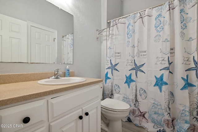 full bath with a shower with shower curtain, toilet, vanity, and a textured wall