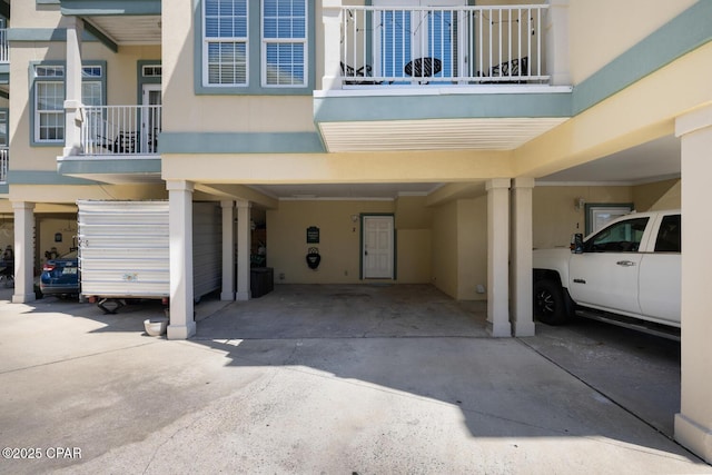 doorway to property with stucco siding and a carport