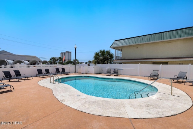 pool with a patio and fence