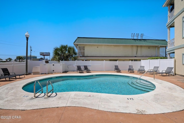 community pool with a patio and fence