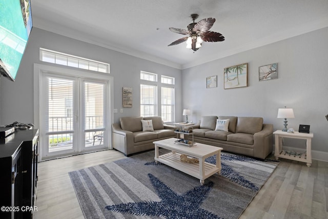 living room featuring ornamental molding, a ceiling fan, and wood finished floors