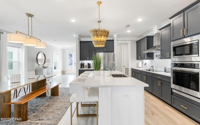 kitchen with stainless steel appliances, a sink, light countertops, tasteful backsplash, and crown molding