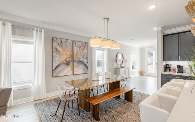 dining space featuring recessed lighting, crown molding, light wood-style flooring, and baseboards