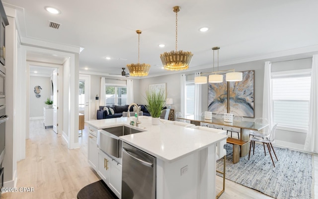 kitchen with dishwasher, a sink, visible vents, and crown molding