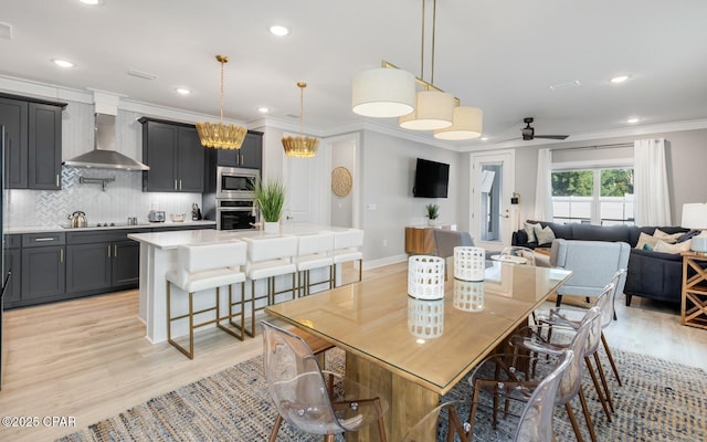 dining room with light wood finished floors, recessed lighting, and crown molding