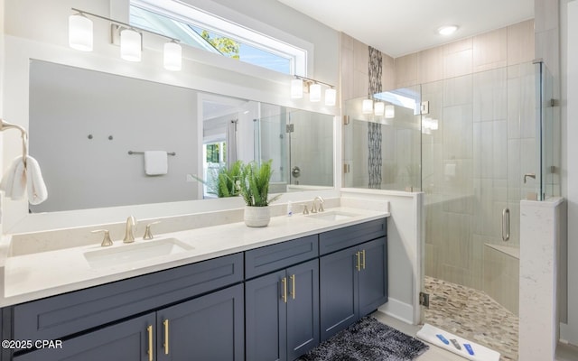 full bath featuring double vanity, a stall shower, and a sink