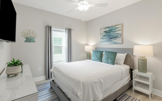 bedroom featuring ceiling fan, light wood-style flooring, and baseboards