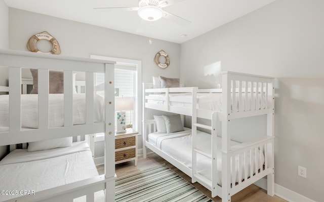 bedroom featuring ceiling fan, baseboards, and wood finished floors