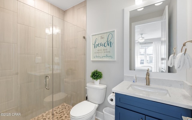 bathroom with toilet, a shower stall, ceiling fan, and vanity