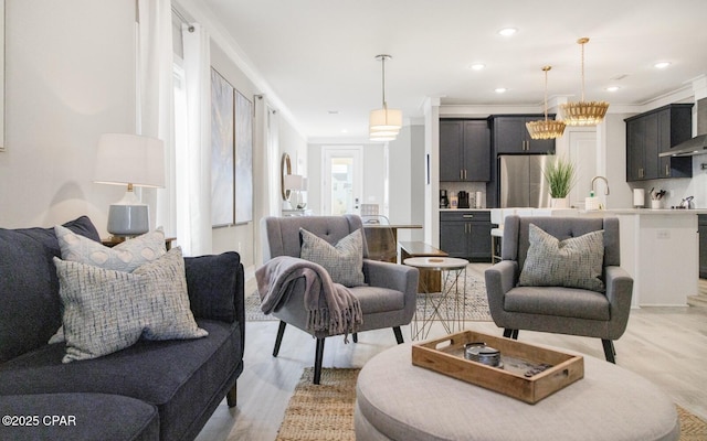 living area with light wood-style floors, recessed lighting, and ornamental molding