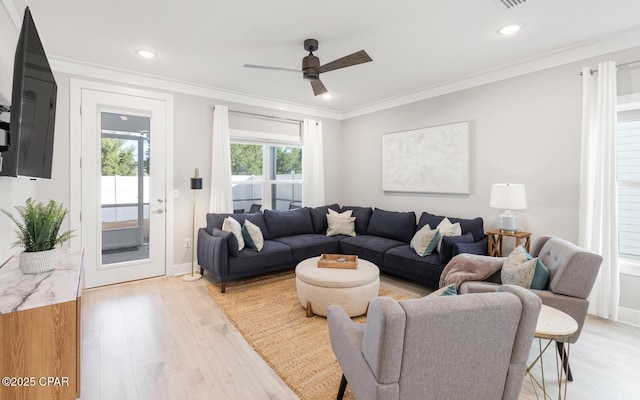 living room featuring ceiling fan, recessed lighting, baseboards, ornamental molding, and light wood-type flooring